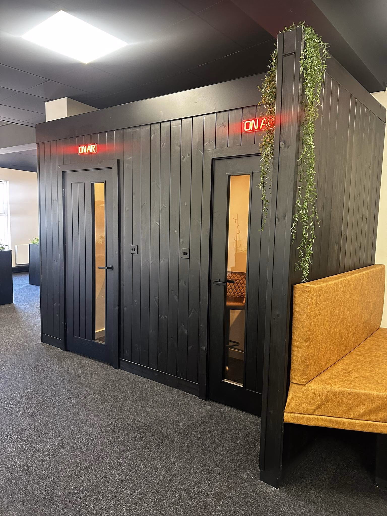 Private call booths beside the open coworking space